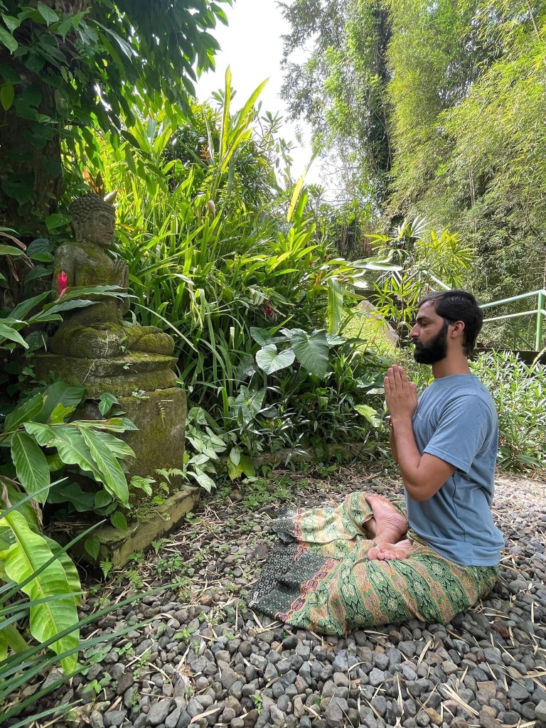 Hatha Yoga Teacher Ayush doing Meditation (Dhyan) in Padmasana (Lotus Pose) with Namaste Mudra. 
Salutation to Buddha. 
Location Bali Indonesia