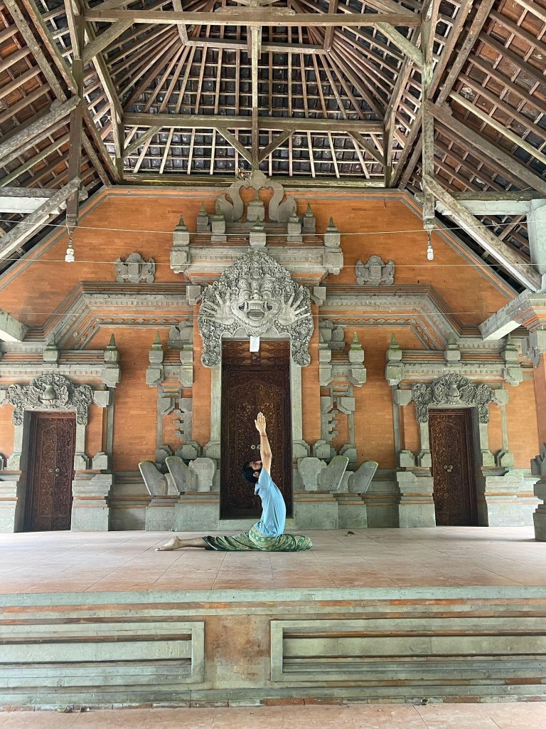 Hatha Yoga Teacher Ayush in Eka Pada Rajkapotasana (Pigeon Pose) Namaste Mudra. 
Location Bali Indonesia.