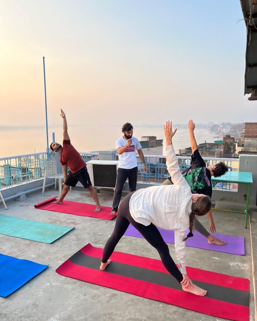 Hatha Yoga Teacher Ayush checking the students postures while teaching his class.