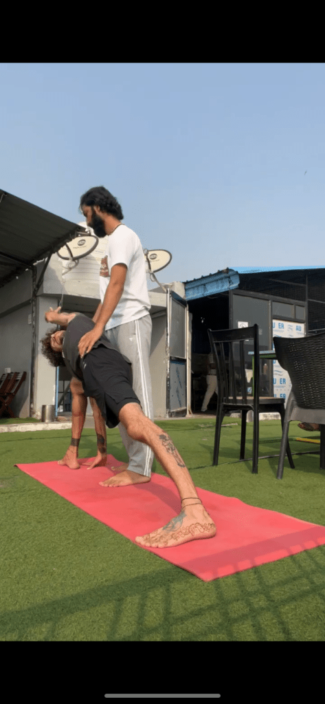 Hathayoga Teacher Ayush checking his student in Utthita Parshvakonasana, Extended Side Angle Pose. 