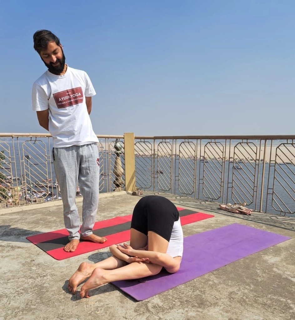 Yoga teacher Ayush student performing Karnapidasna. 