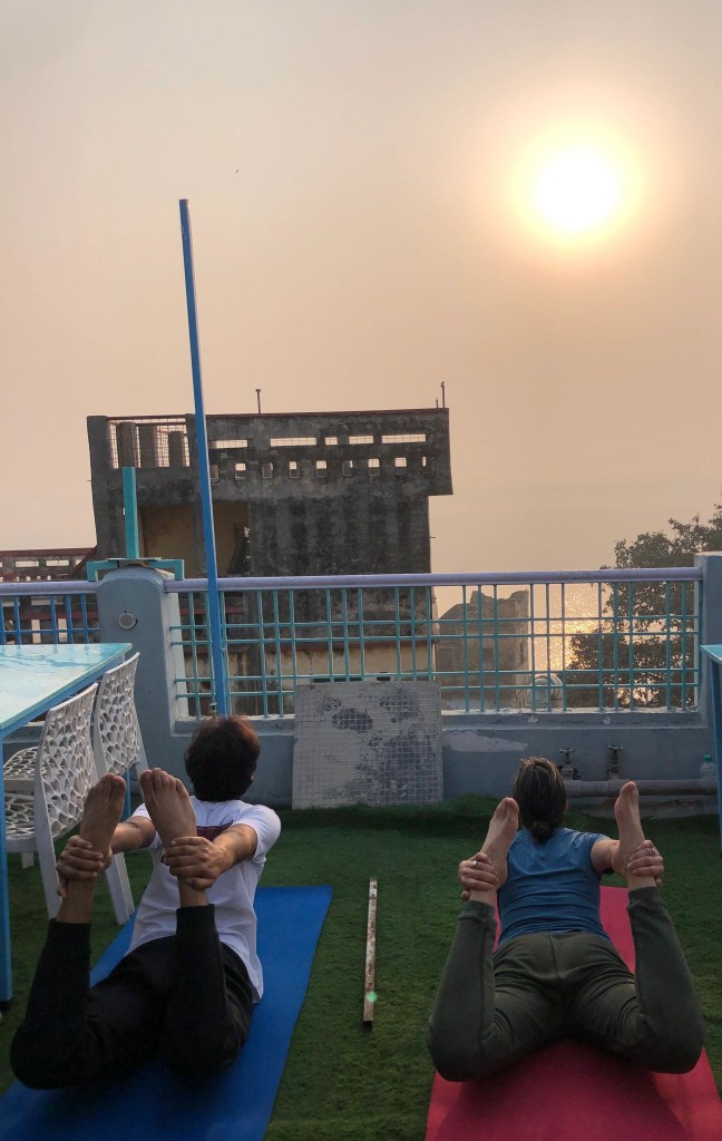 Yoga teacher Ayush with his student in Dhanurasana. 