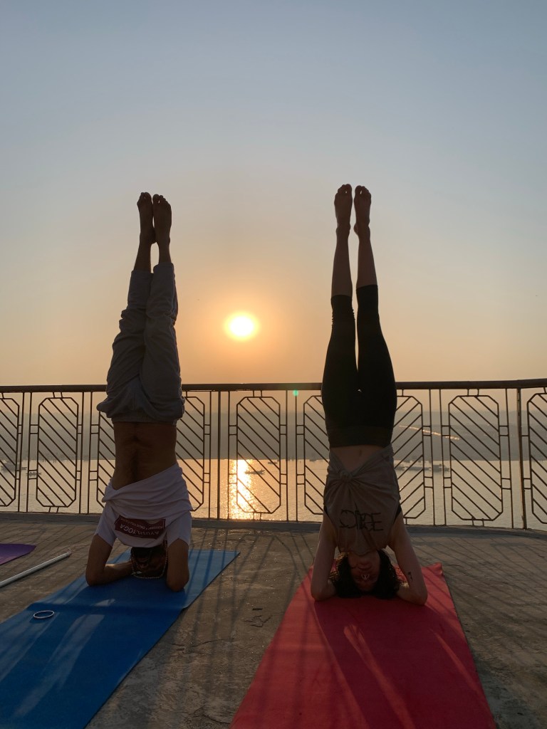 Yoga teacher Ayush with his student performing Sirshasana together. 