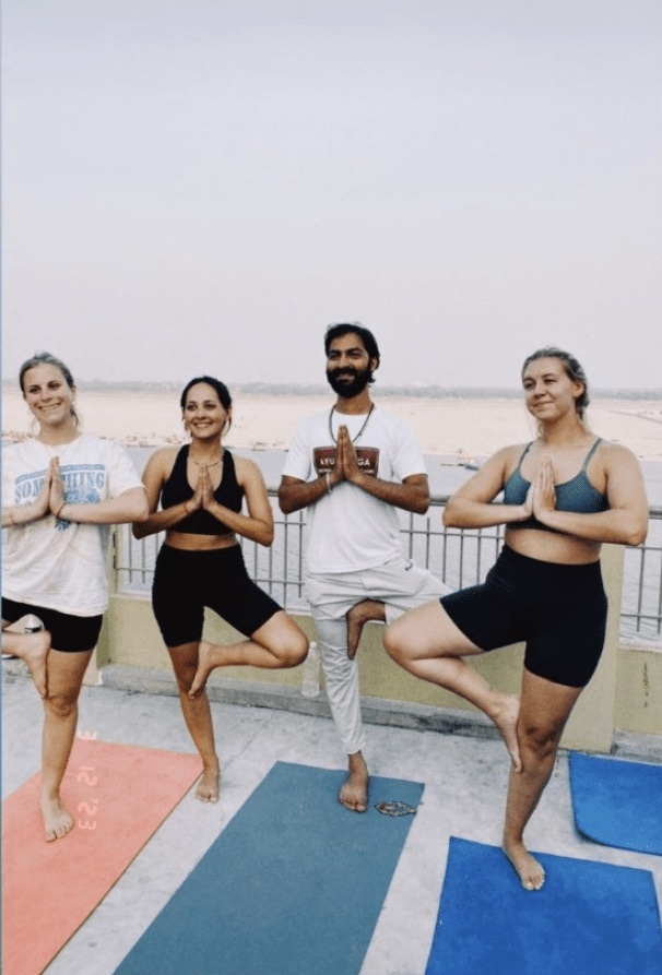 Yoga teacher Ayush with his students in Vrikshasana. 