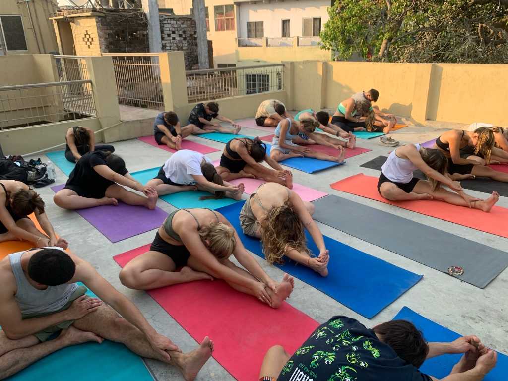 Students are perfect Janu Sirasana over looking Ganga on the rooftop.