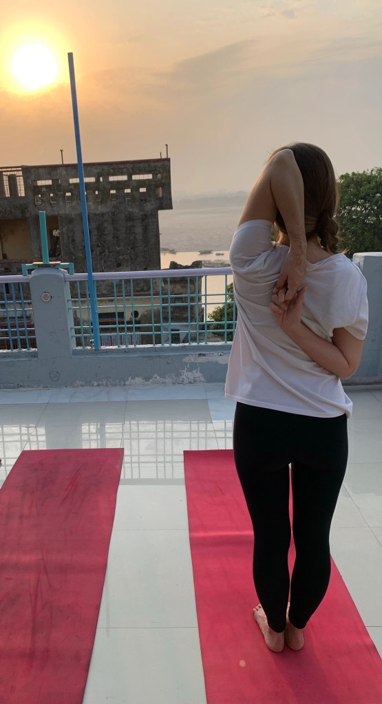 Yoga teacher Ayush student performing Tadasana Gomukhasana (Standing Cow Face Pose)