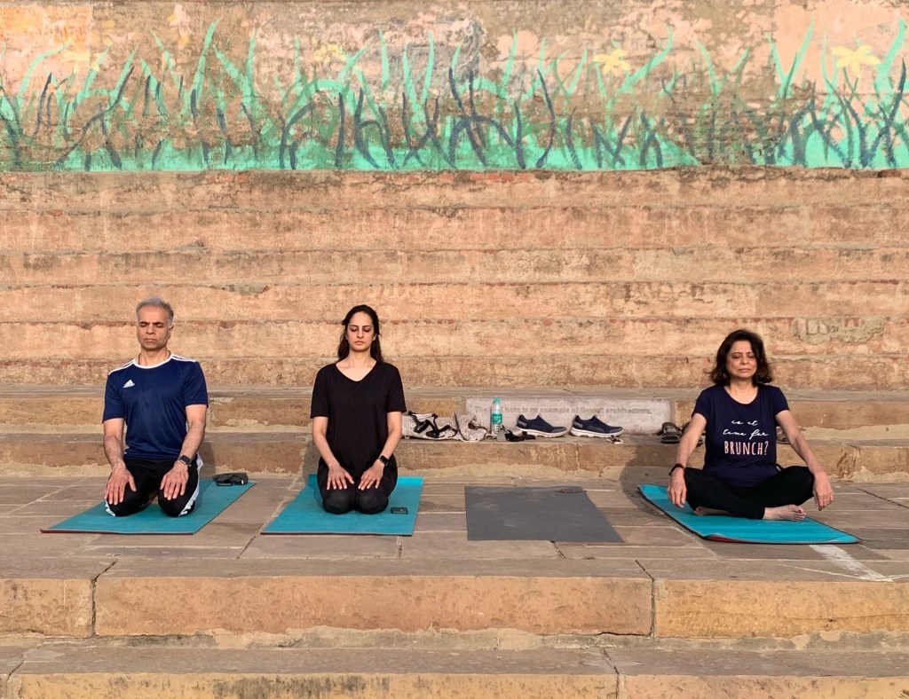 Yoga teacher Ayush students performing Vajrasana in Varanasi over looking Ganga. 