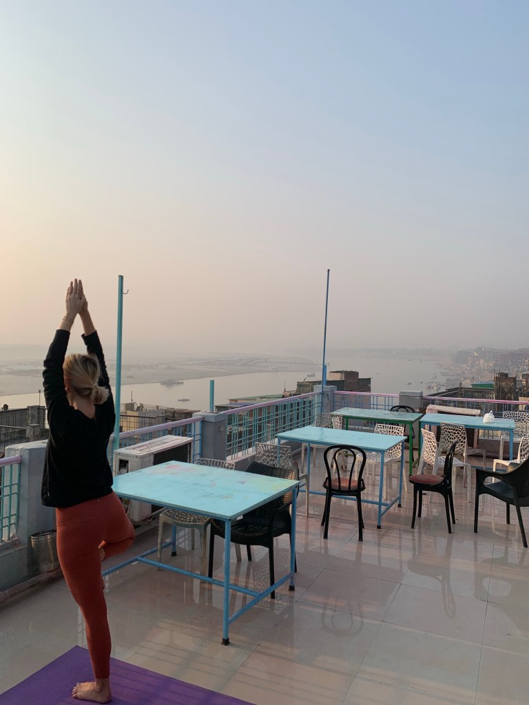Yoga teacher Ayush students performing Tree Pose overlooking Ganga. 