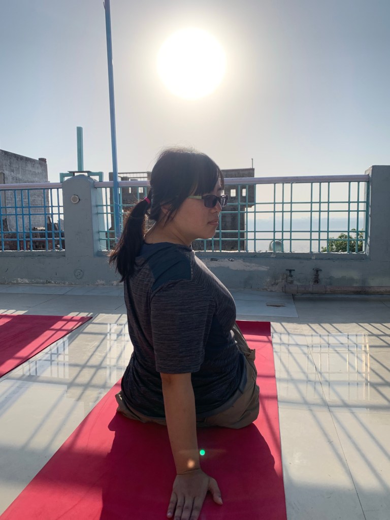 Yoga teacher Ayush student performing Spinal Twist Pose in Varanasi. 