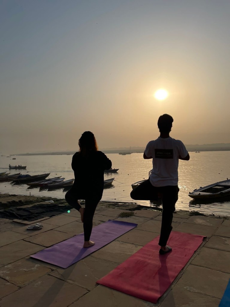 Yoga teacher Ayush with his student doing Sunrise Yoga over looking Ganga in Varanasi. 