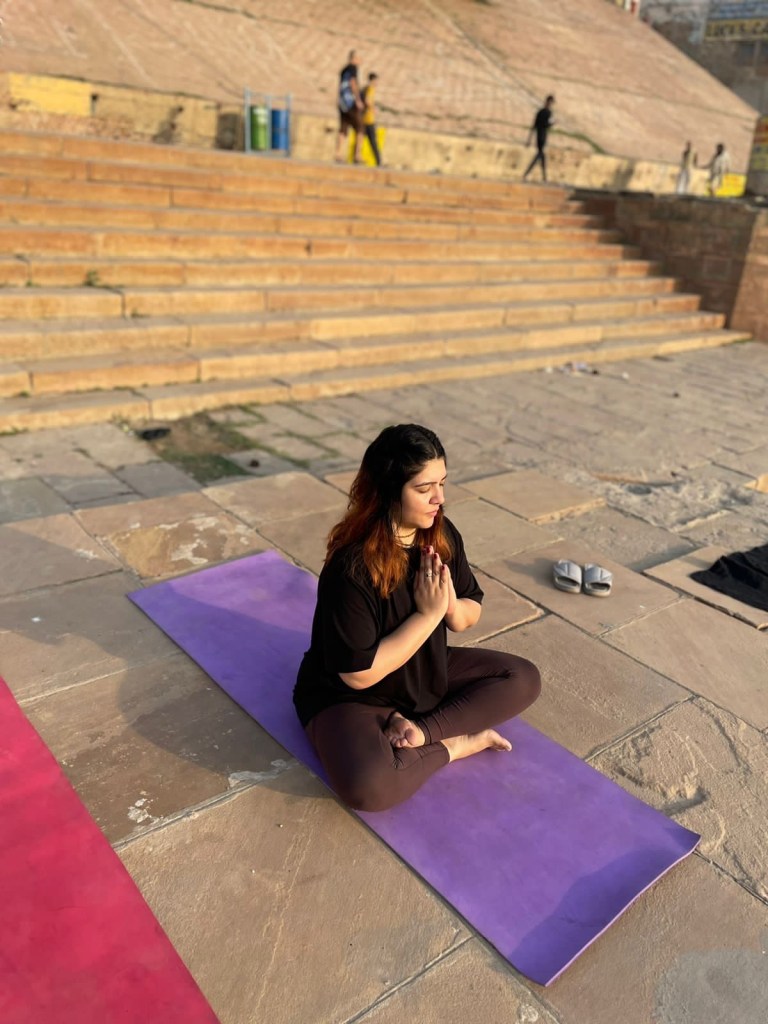Yoga teacher Ayush student in meditation Pose with namaste Mudra in Varanasi. 